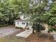 Lush trees surround this classic home, with a view of the driveway and yard at 914 S Main St, Summerville, SC 29483