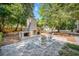 Backyard with brick fireplace, paver patio, and mature trees providing shade and privacy at 914 S Main St, Summerville, SC 29483