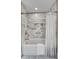 Bathroom showcasing marble tiled walls, bronze fixtures, and a bright white shower curtain at 914 S Main St, Summerville, SC 29483