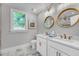 Bathroom featuring double sinks, marble countertops, and round mirrors at 914 S Main St, Summerville, SC 29483