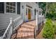 Inviting front porch with brick steps, white railings, and a wreath on the wooden front door at 914 S Main St, Summerville, SC 29483
