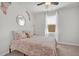 Charming bedroom with a coral bedspread, a round mirror, a decorative shelving unit, and a sunlit window at 9700 Flooded Field Drive Dr, Ladson, SC 29456
