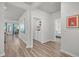 Inviting hallway showcases modern wood-look flooring, a laundry room, and leads to a sunlit living area and cozy bedroom at 9700 Flooded Field Drive Dr, Ladson, SC 29456