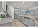 Modern kitchen featuring gray cabinets, stainless steel appliances, granite countertops, and an open view to the living area at 9700 Flooded Field Drive Dr, Ladson, SC 29456