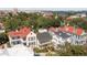 An aerial view of a neighborhood showcasing houses with colorful roofs and lush trees, with a bridge in the background at 10 Water St, Charleston, SC 29401