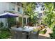 Outdoor patio and backyard featuring a dining table, lounge area, and beautiful landscaping at 10 Water St, Charleston, SC 29401