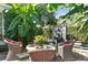 Secluded brick patio adorned with lush greenery, banana trees, a tranquil water feature, and comfortable wicker seating at 10 Water St, Charleston, SC 29401