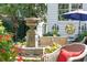 Inviting backyard featuring a stone fountain, wicker chairs and tables, and lush green landscaping and flowers at 10 Water St, Charleston, SC 29401