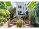 Charming backyard featuring a fountain, lush greenery, and outdoor seating with beautiful red accents at 10 Water St, Charleston, SC 29401