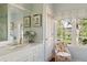 Charming bathroom with a marble vanity, floral chair by window, and ample natural light at 10 Water St, Charleston, SC 29401