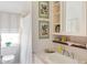 Well-lit bathroom with a sink, a shower with a curtain, and decorative artwork adding a personal touch at 10 Water St, Charleston, SC 29401
