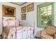 Quaint bedroom with a patterned quilt on an iron bed frame, complemented by art and a decorative chair at 10 Water St, Charleston, SC 29401