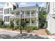 Charming two-story home featuring a double porch, brick pathway, and lush landscaping at 10 Water St, Charleston, SC 29401