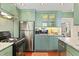 Well-lit kitchen featuring green cabinets, stainless steel appliances, and hardwood floors at 10 Water St, Charleston, SC 29401