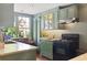 Charming green kitchen with stainless steel appliances, stone countertops, and a view to the backyard at 10 Water St, Charleston, SC 29401