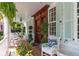 Charming porch with comfortable seating, plants, and wooden door at 10 Water St, Charleston, SC 29401