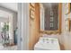 Charming powder room featuring a wall-mounted sink, decorative mirror, and unique artwork at 10 Water St, Charleston, SC 29401