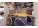 Modern laundry room with front-load washer and dryer, folding counter, and storage shelves at 103 Haleswood Cir, Goose Creek, SC 29445