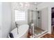 Well lit bathroom features wood floors, a soaking tub, frameless shower, and unique lighting at 104 Abrum Ct, Goose Creek, SC 29445