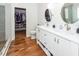 Modern bathroom featuring double sinks, walk-in closet, wood floors, and white cabinets at 104 Abrum Ct, Goose Creek, SC 29445
