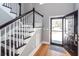 Bright foyer features hardwood floors, staircase with white railings, and a black front door at 104 Abrum Ct, Goose Creek, SC 29445