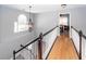 Second floor hallway with hardwood floors, and dark wood and white spindles, leading to dining room at 104 Abrum Ct, Goose Creek, SC 29445