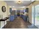 Bright kitchen with blue cabinets, stainless steel appliances, and a sliding glass door leading to the backyard at 104 Salem Rd, Ladson, SC 29456