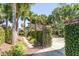 Lush backyard oasis with mature palm trees, brick gate, and charming garden path at 106 Murray Blvd, Charleston, SC 29401