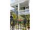 Elegant curved stairs leading to the porch, framed by lush greenery and black iron railings at 106 Murray Blvd, Charleston, SC 29401