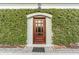 Charming entrance with a wooden front door surrounded by lush greenery at 106 Murray Blvd, Charleston, SC 29401