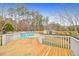 Wooden back deck view overlooking a swimming pool with white railing at 1158 Wildgame Rd, Summerville, SC 29486