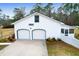 Spacious two-car garage with white doors and white trim, surrounded by greenery at 1158 Wildgame Rd, Summerville, SC 29486