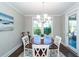 Bright dining area with a round table, white chairs, and a window overlooking the outdoor landscape at 1166 Elliotts Cut Dr, Charleston, SC 29412