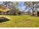 Lush backyard with a covered patio and a glimpse of the neighborhood beyond the wooden fence at 1198 Oakcrest Dr, Charleston, SC 29412