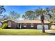 Charming brick ranch with red shutters and a well-maintained front yard with mature trees at 1198 Oakcrest Dr, Charleston, SC 29412