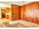 Cozy living room with wood paneling and carpet floors, flowing into the kitchen at 1198 Oakcrest Dr, Charleston, SC 29412