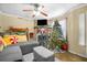 Comfortable living room featuring a stone fireplace, gray sofa, bicycles, and a festive Christmas tree at 120 Luden Dr # C, Summerville, SC 29483