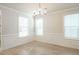 Sunlit dining room features classic wainscoting and modern chandelier, with neutral walls and wood flooring at 125 Cantona Dr, Summerville, SC 29483
