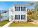 Charming two-story home featuring a bright white exterior with black shutters and a cozy covered porch at 125 Cantona Dr, Summerville, SC 29483