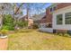 View of a backyard lawn, deck, white fence, brick house, and mature trees at 1324 Southlake Dr, Mount Pleasant, SC 29464