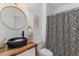 This bathroom has a wood vanity, round mirror, and unique black and white shower curtain at 1324 Southlake Dr, Mount Pleasant, SC 29464