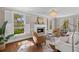 Comfortable living room with a fireplace, large windows overlooking the pool, and a dining area at 1324 Southlake Dr, Mount Pleasant, SC 29464