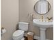 Charming powder room has pedestal sink with modern fixtures and round mirror at 1324 Southlake Dr, Mount Pleasant, SC 29464