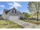 Side view of a house with a two-car garage, featuring an extended driveway, healthy lawn, and mature tree at 136 Rosario Dr, Summerville, SC 29483