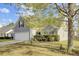 View of home with grey siding, a two-car garage, and beautiful mature trees and bushes at 136 Rosario Dr, Summerville, SC 29483