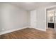 Bedroom leading to en-suite bathroom showcasing natural light, neutral paint and wood flooring at 1427 Homecoming Blvd, Ravenel, SC 29470