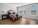 Comfortable bedroom features wood flooring, two windows, and neutral color palette at 1427 Homecoming Blvd, Ravenel, SC 29470