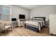 This primary bedroom features a beautiful bed, dresser, and chair and also includes lots of natural light at 1427 Homecoming Blvd, Ravenel, SC 29470