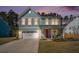 Charming two-story home with light blue siding, white trim, and a bright red front door at twilight at 1427 Homecoming Blvd, Ravenel, SC 29470