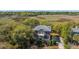 Aerial shot showcases the stately brick home nestled amongst lush trees with a beautiful marsh backdrop at 1521 Hurtes Island Dr, Charleston, SC 29407